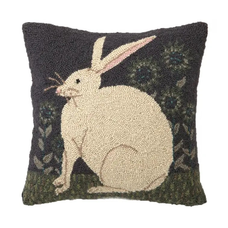 Decorative pillow with a white rabbit design on a dark background
