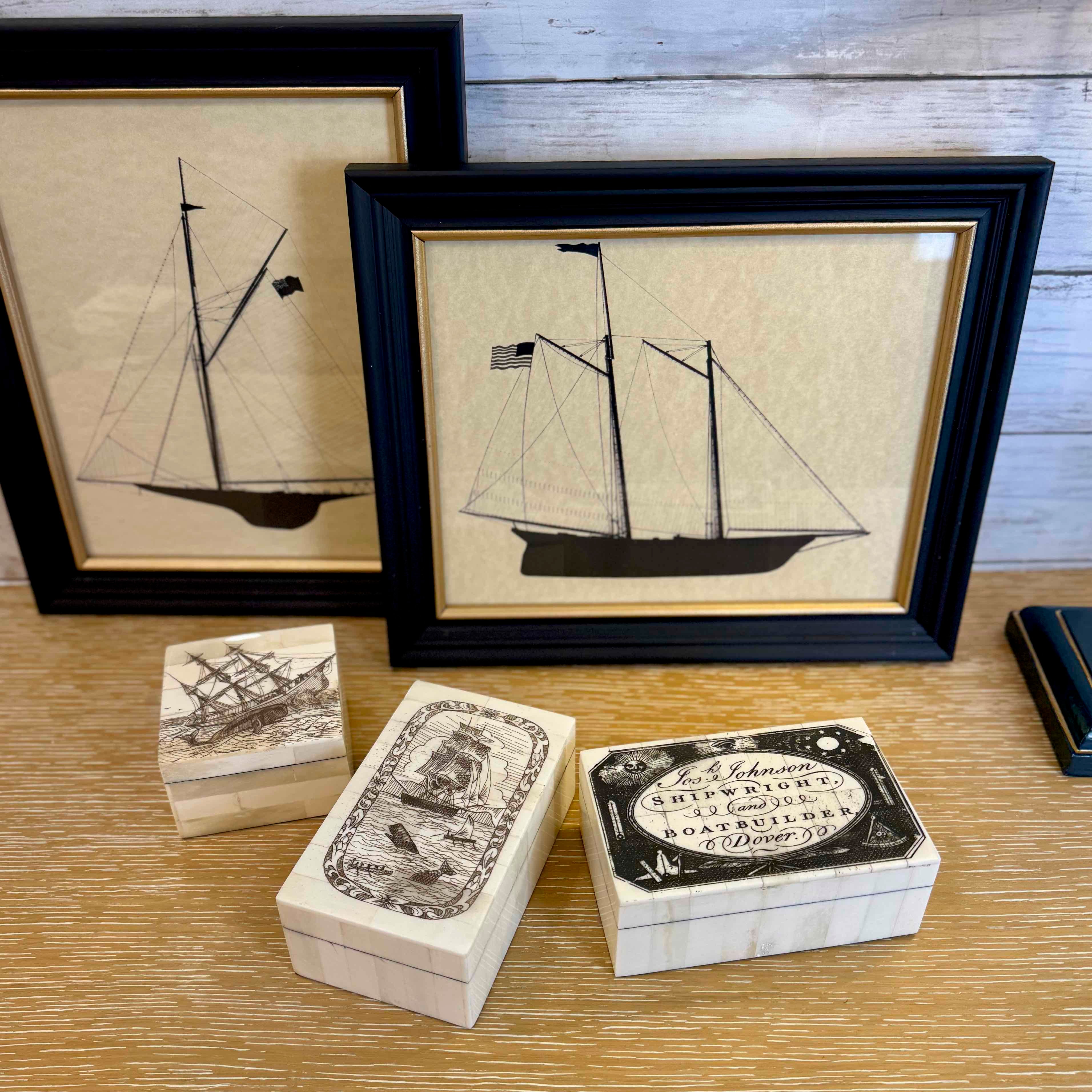 Framed artwork of a ship on a wooden surface with matching boxes.