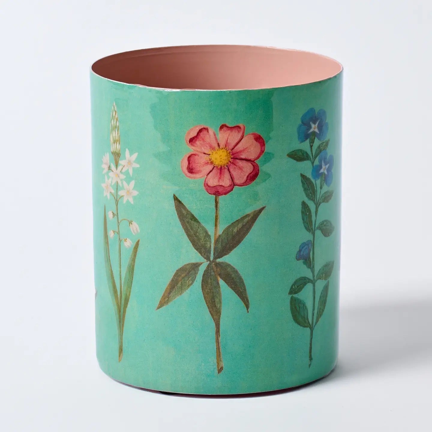 Decorative cylindrical container with floral designs on a light blue background