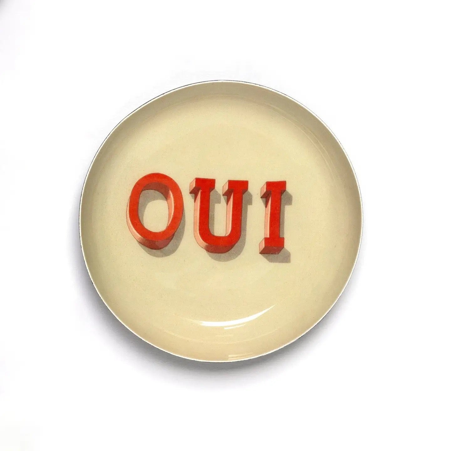 Round beige plate with red 'OUI' text on a white background