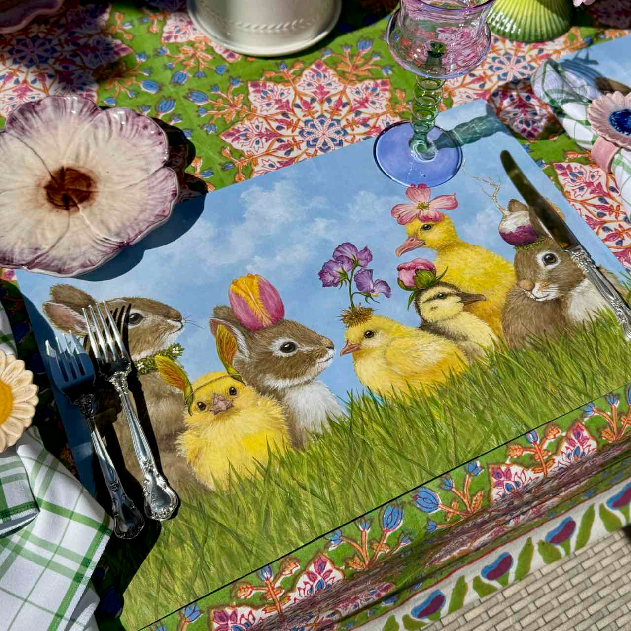 Placemat with Easter design featuring bunnies and chicks on a decorated table.