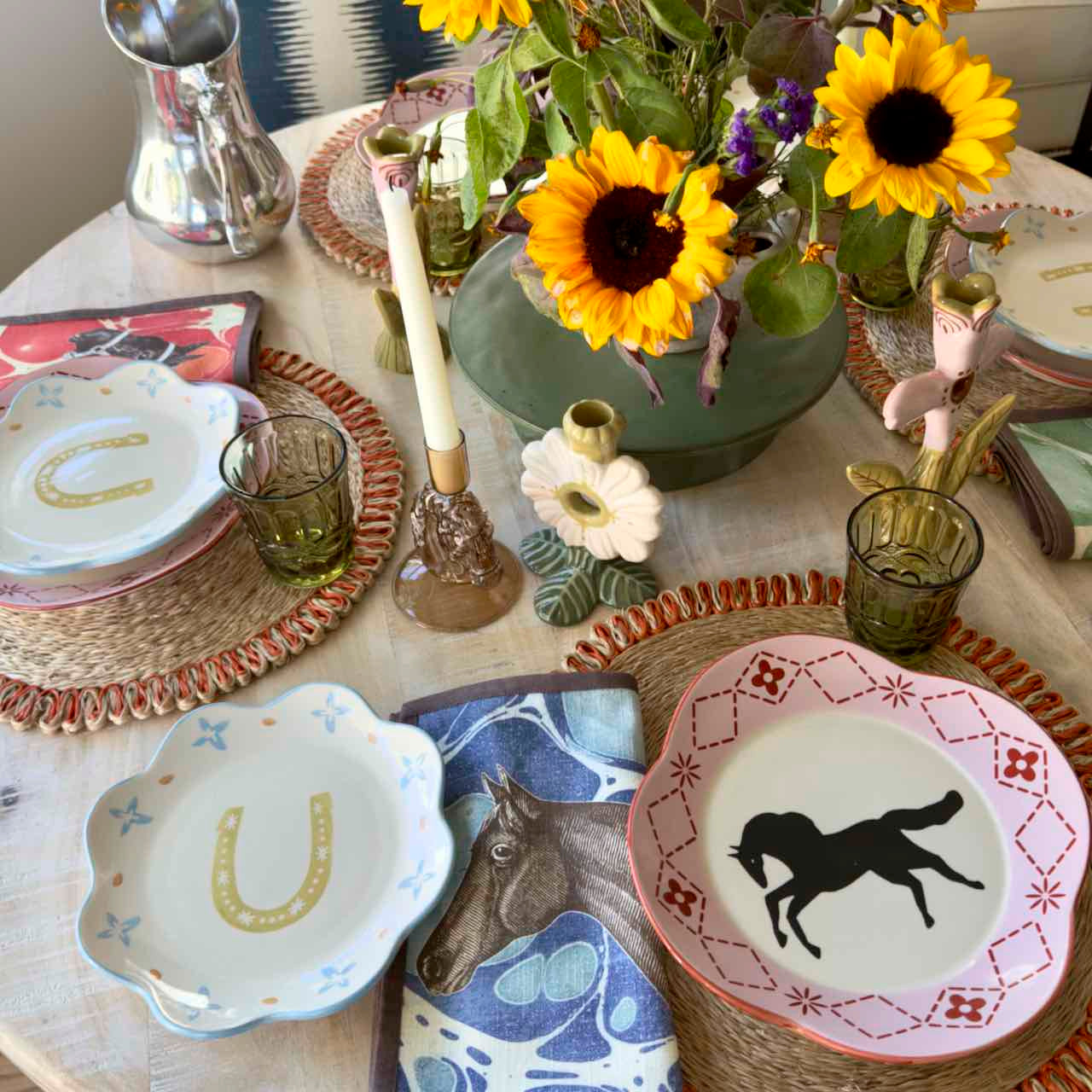 Decorative table setting with horse-themed plates and sunflowers.