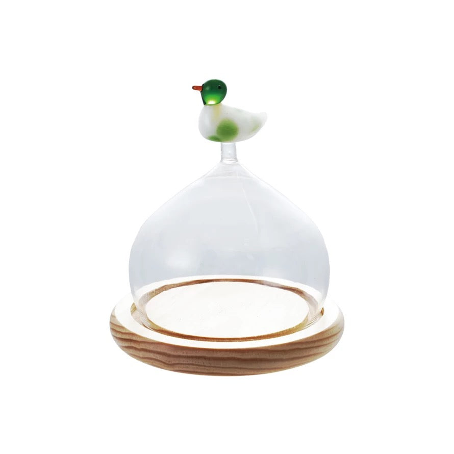 Decorative object with a white top, green accent, and wooden base on a white background