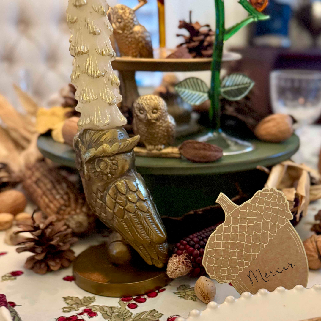 Decorative owl figurine with a tree on a table with autumn-themed items.