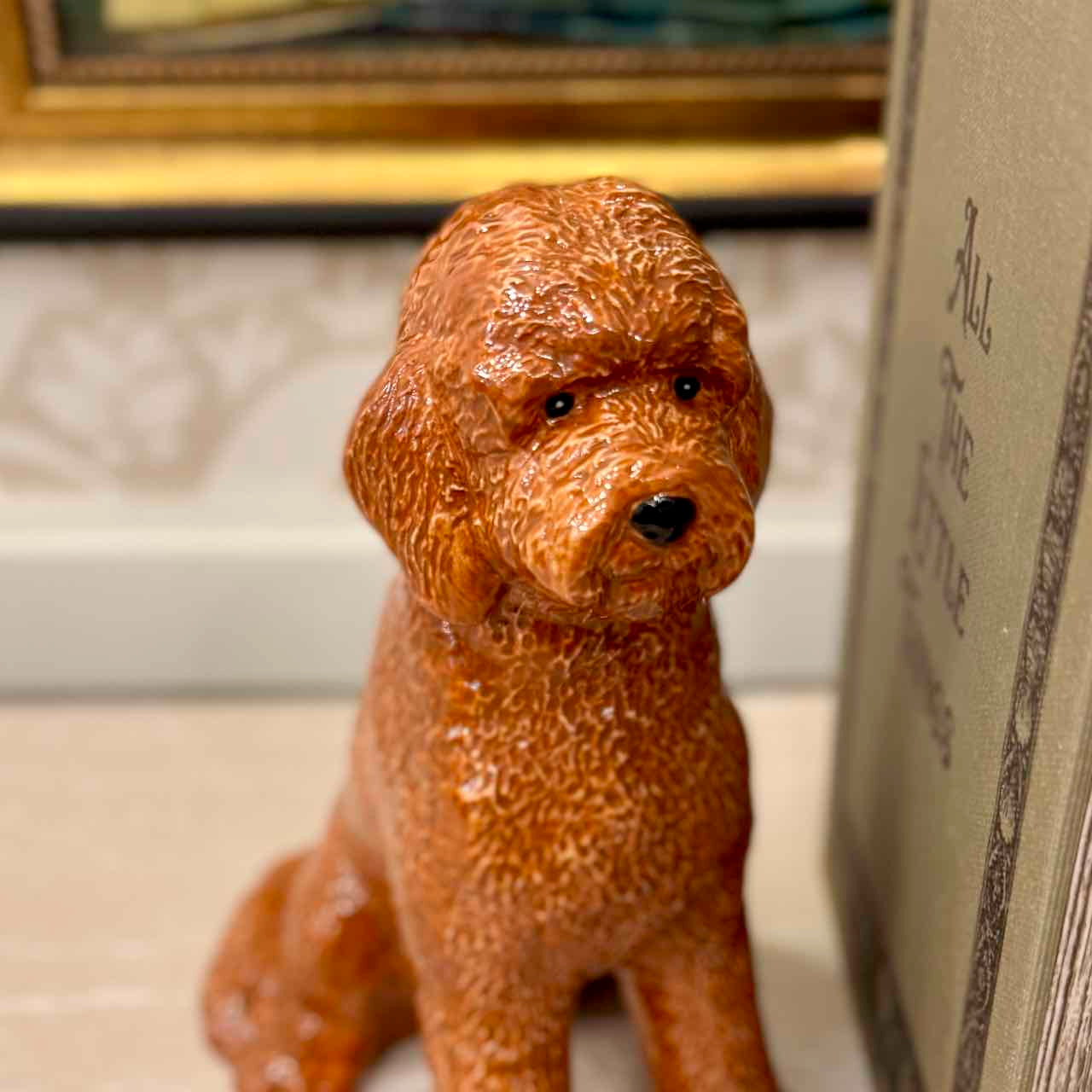 Brown dog figurine next to a book on a surface