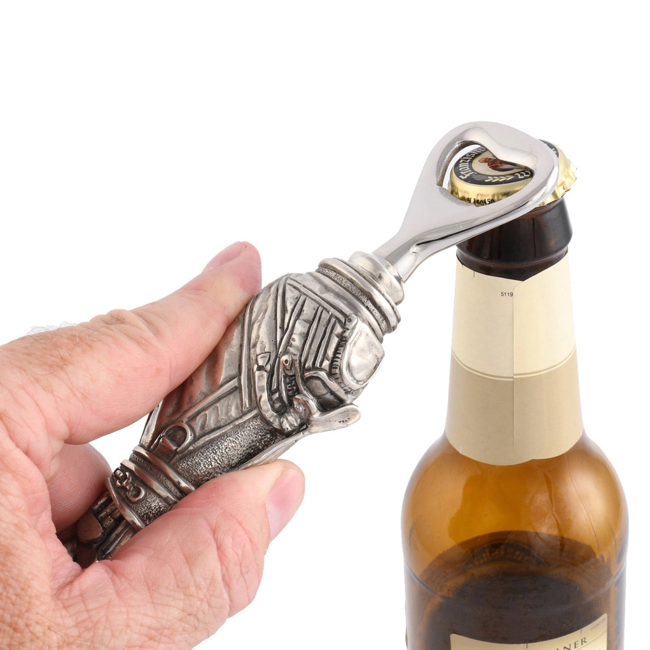Hand using a decorative bottle opener on a bottle against a white background