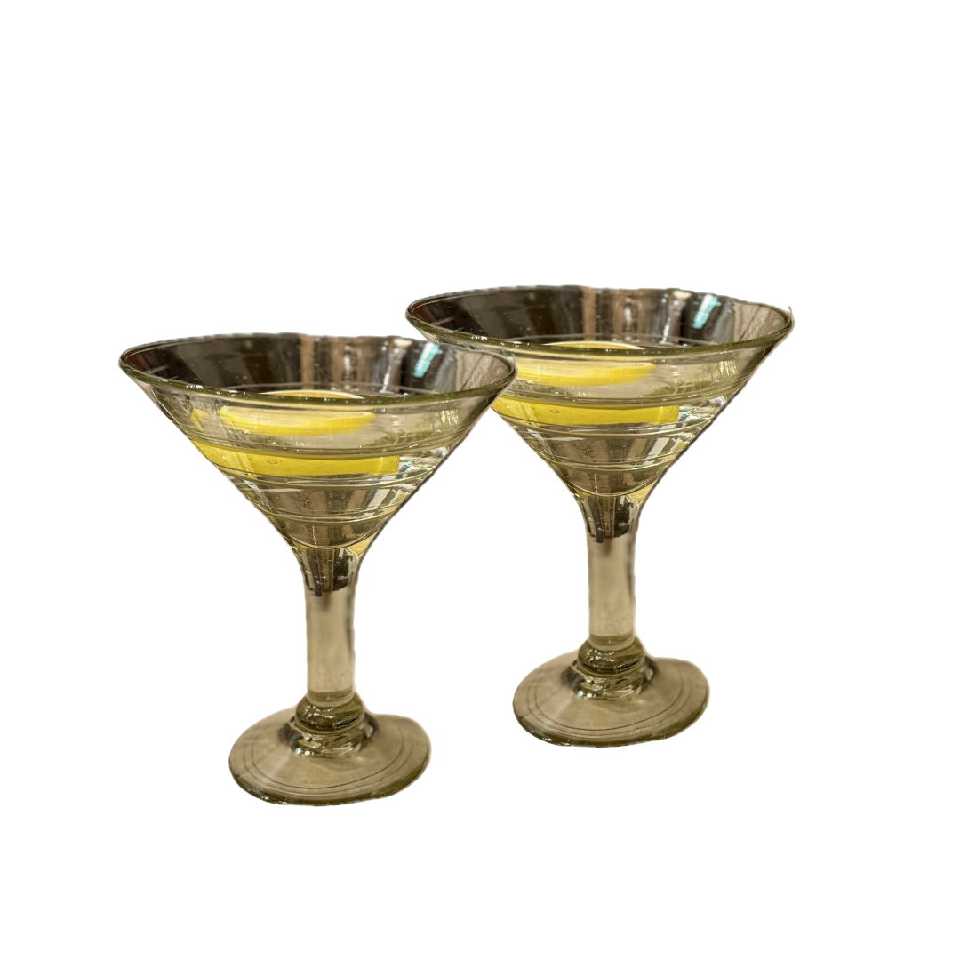 Two silver-rimmed martini glasses on a white background