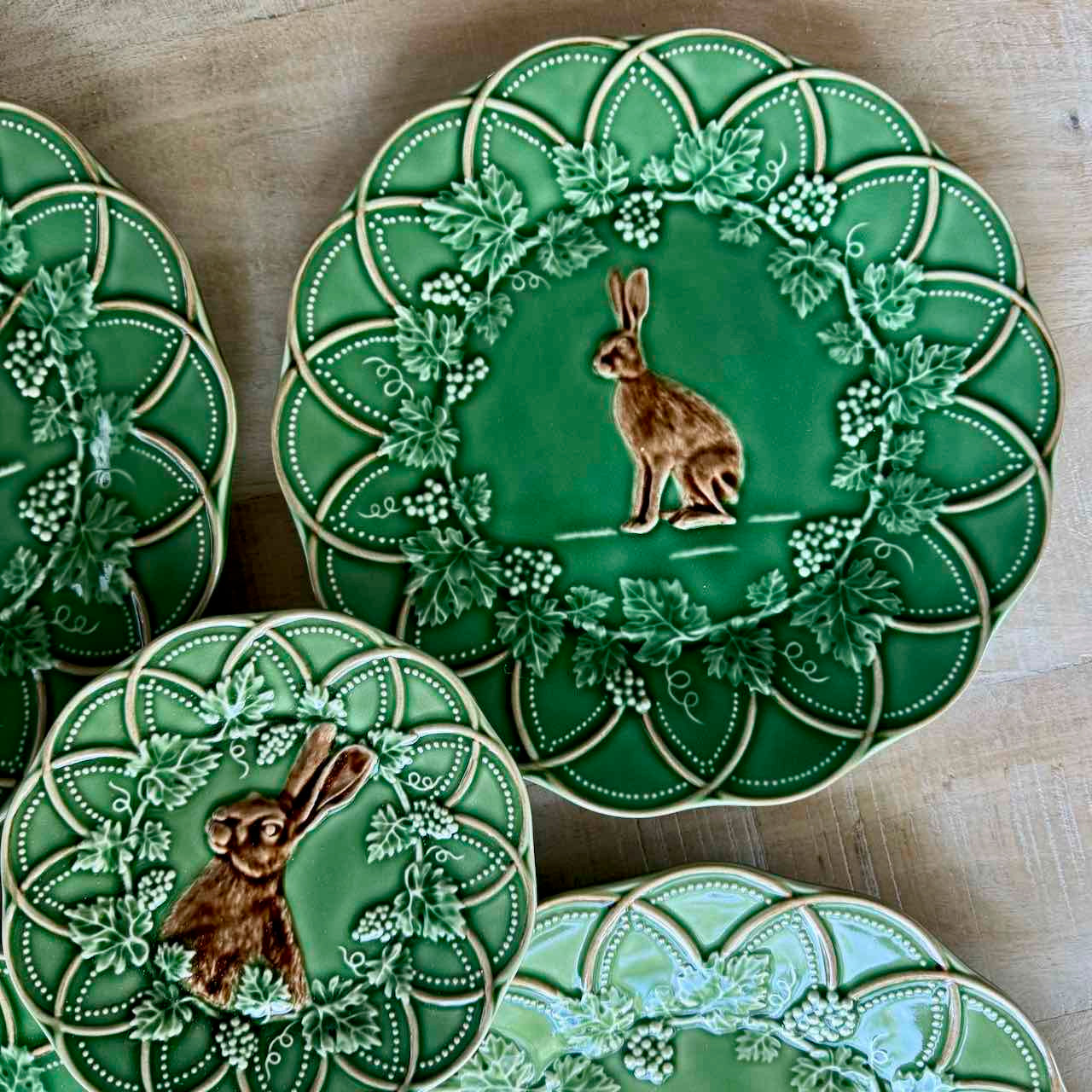 Green ceramic plates with rabbit designs on a wooden surface
