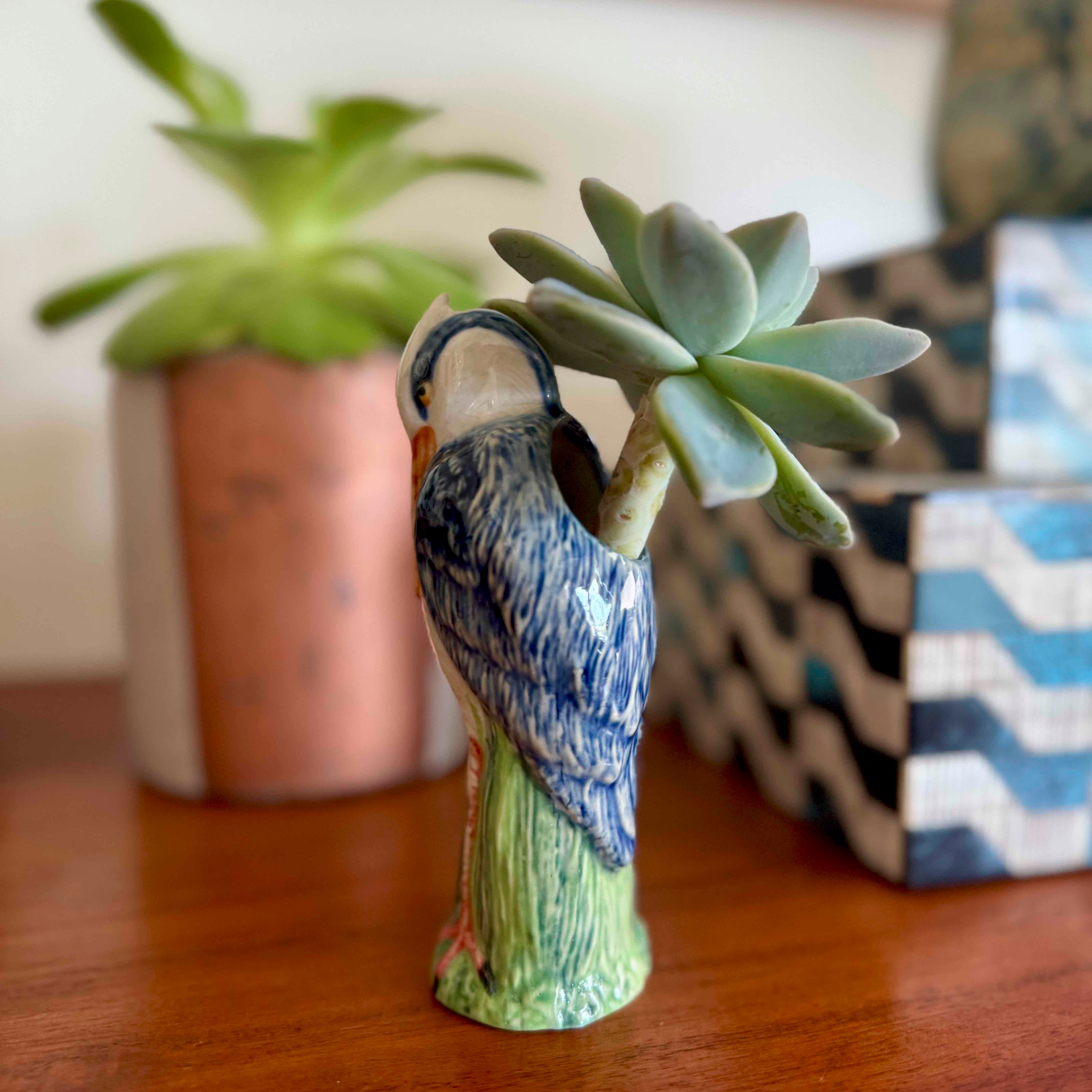 Decorative owl-shaped vase with a succulent plant on a wooden surface.