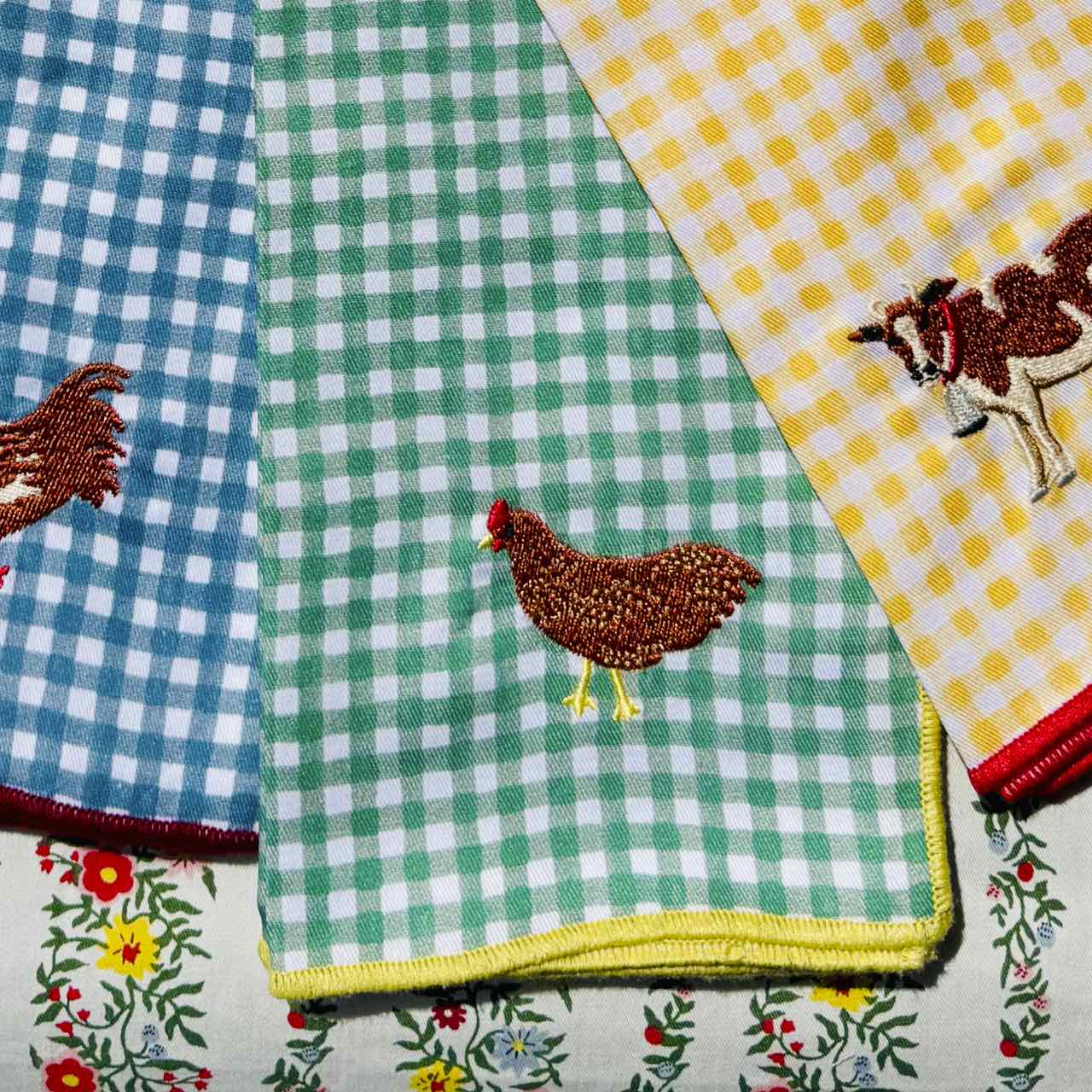 Set of fabric napkins with various patterns including checkered, floral, and animal designs.