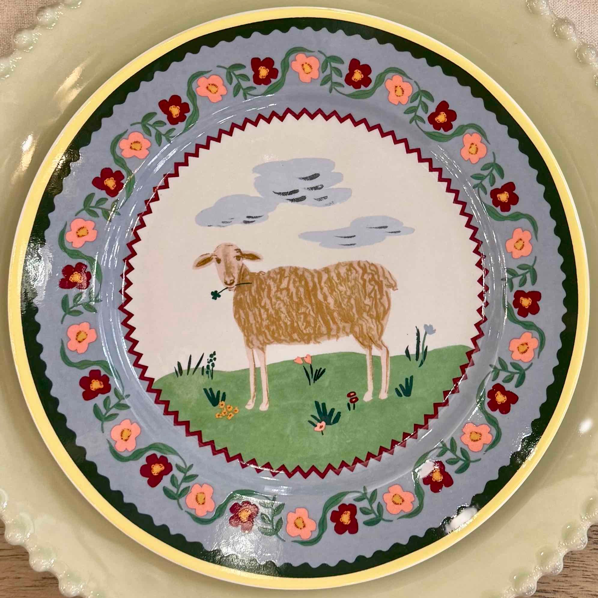 Decorative plate with a sheep illustration and floral design on a beige background
