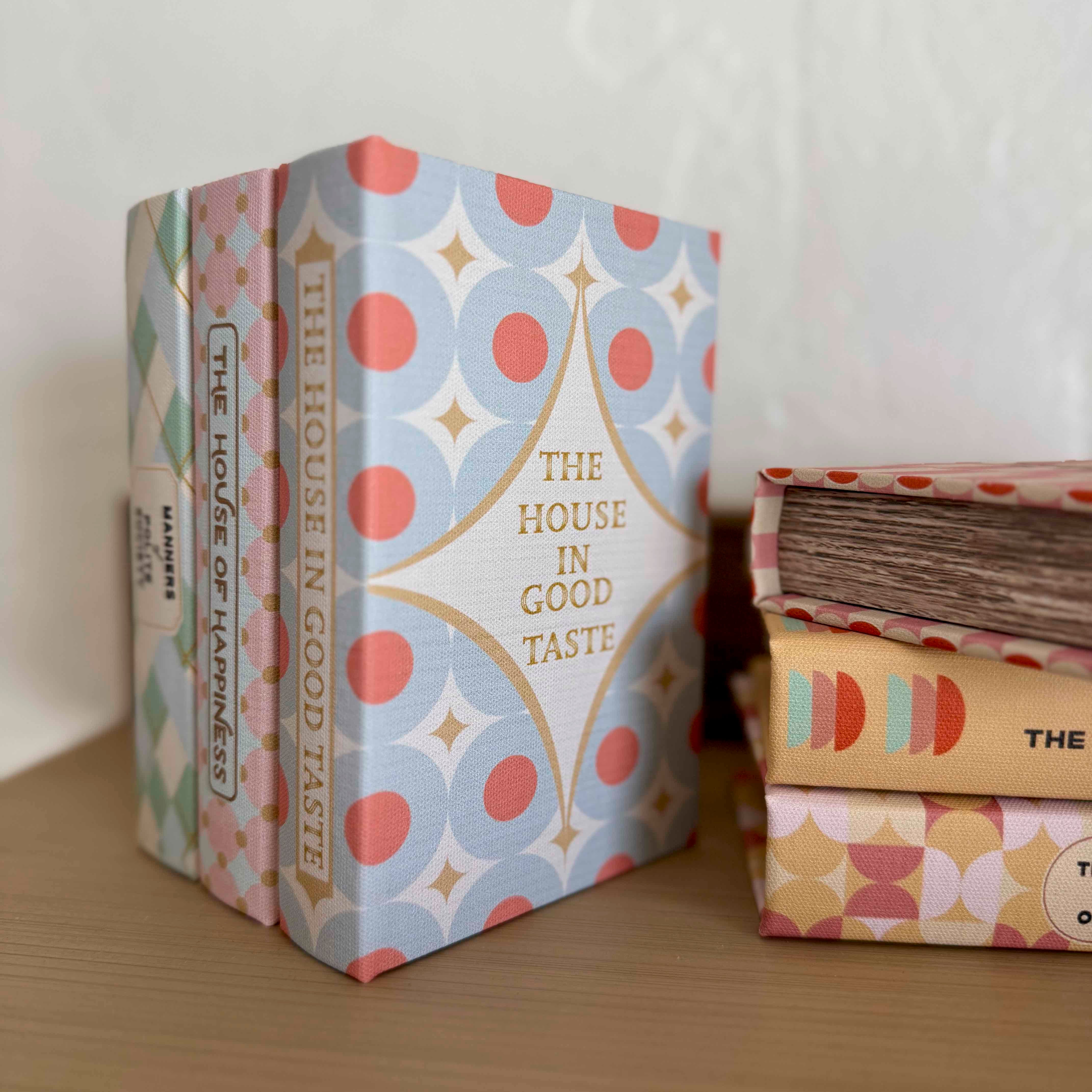 Stack of books with decorative covers on a wooden surface