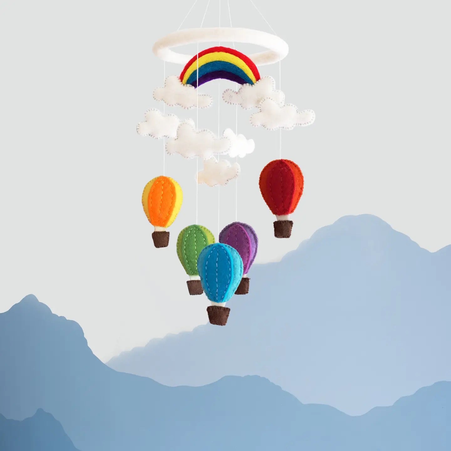 Colorful hot air balloon and rainbow mobile against a mountain backdrop