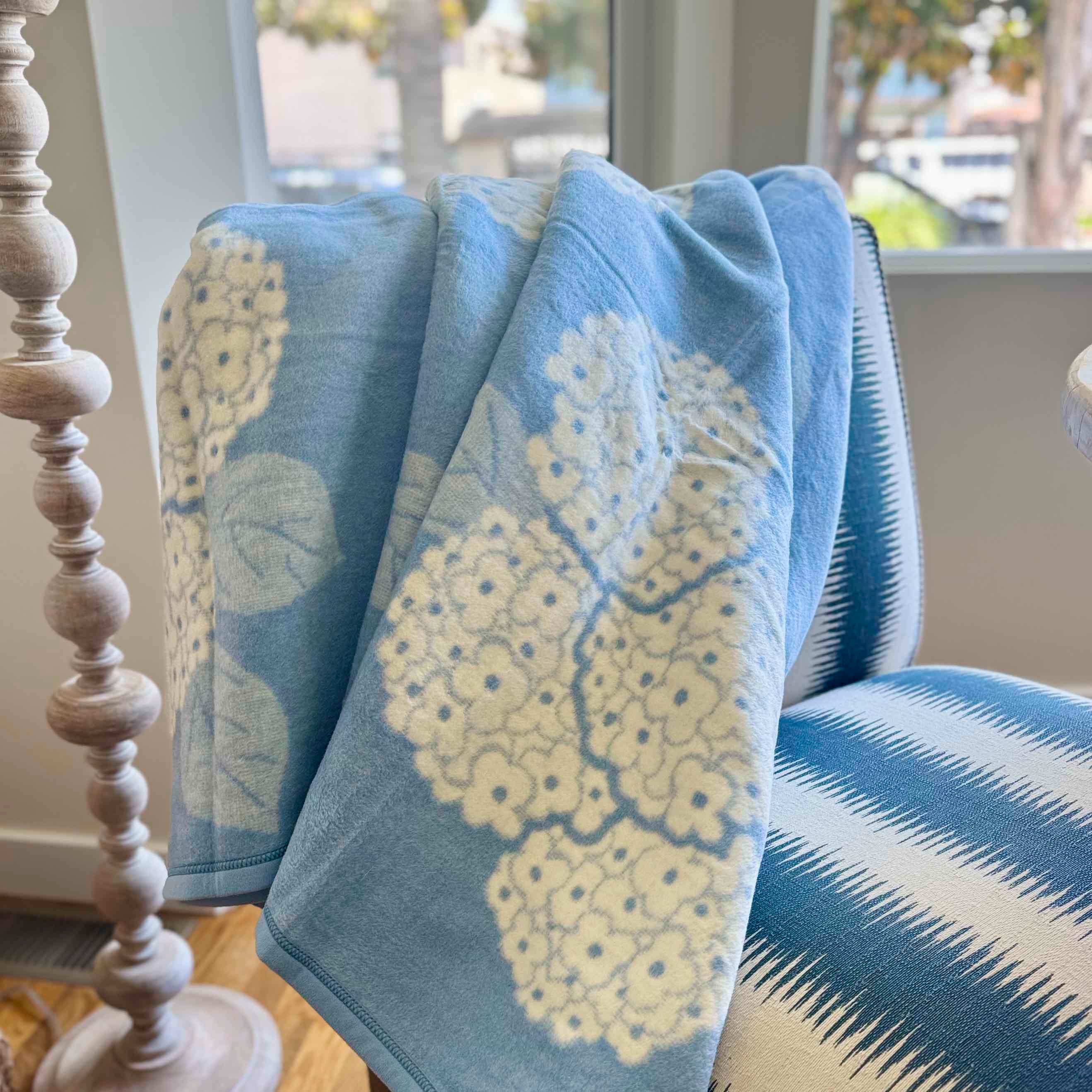 Blue and yellow patterned blanket draped over a chair near a window.