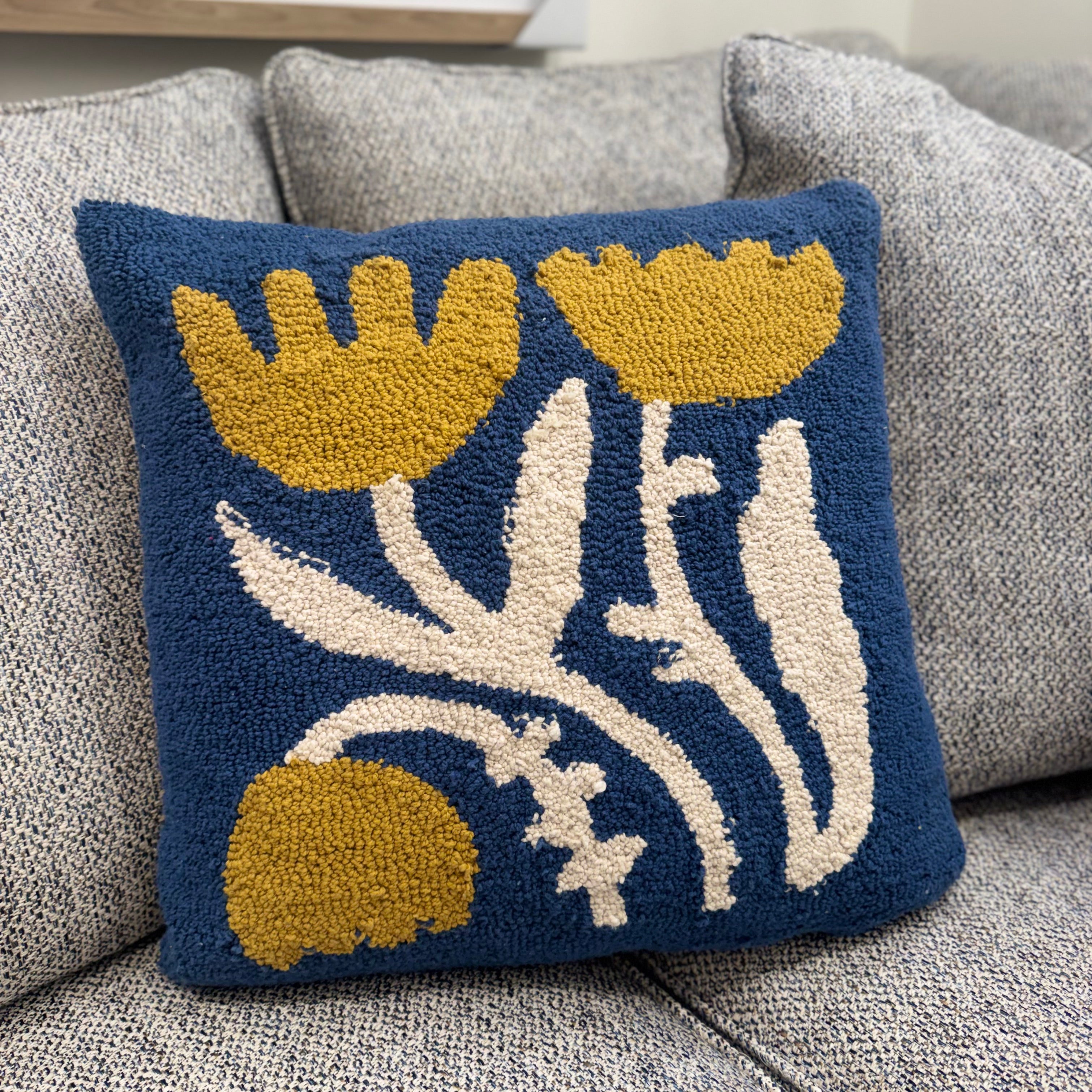Decorative pillow with floral pattern on a gray sofa