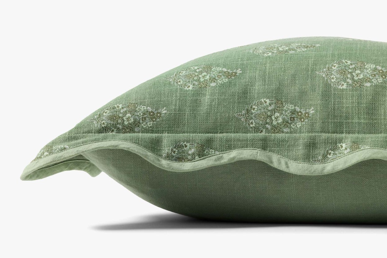 Green decorative pillow with floral embroidery on a white background