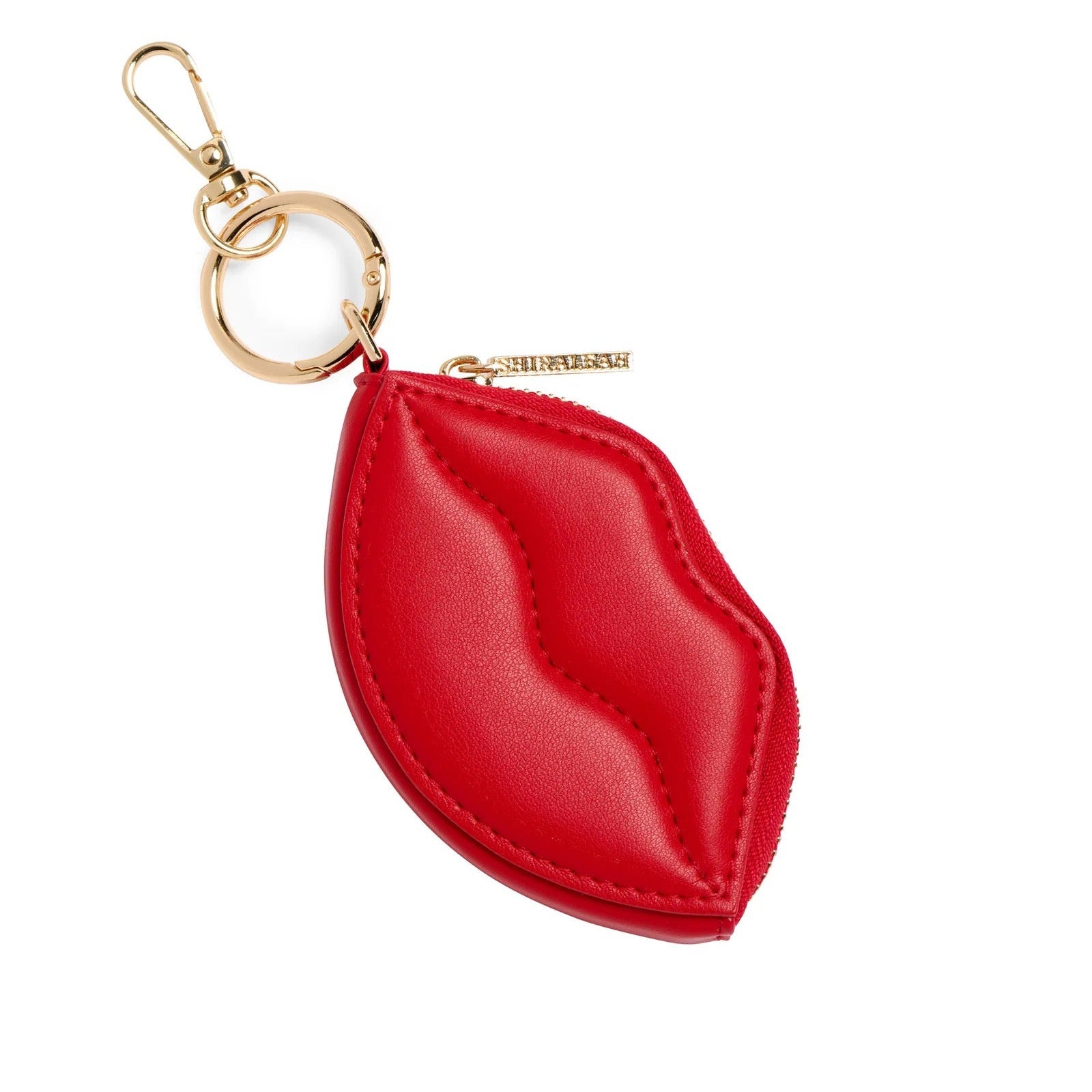 A red leather keychain shaped like lips with gold-tone hardware, including a lobster clasp, key ring, and a small branded tag, shown on a plain white background.