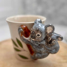 Ceramic cup with koala design on a wooden surface