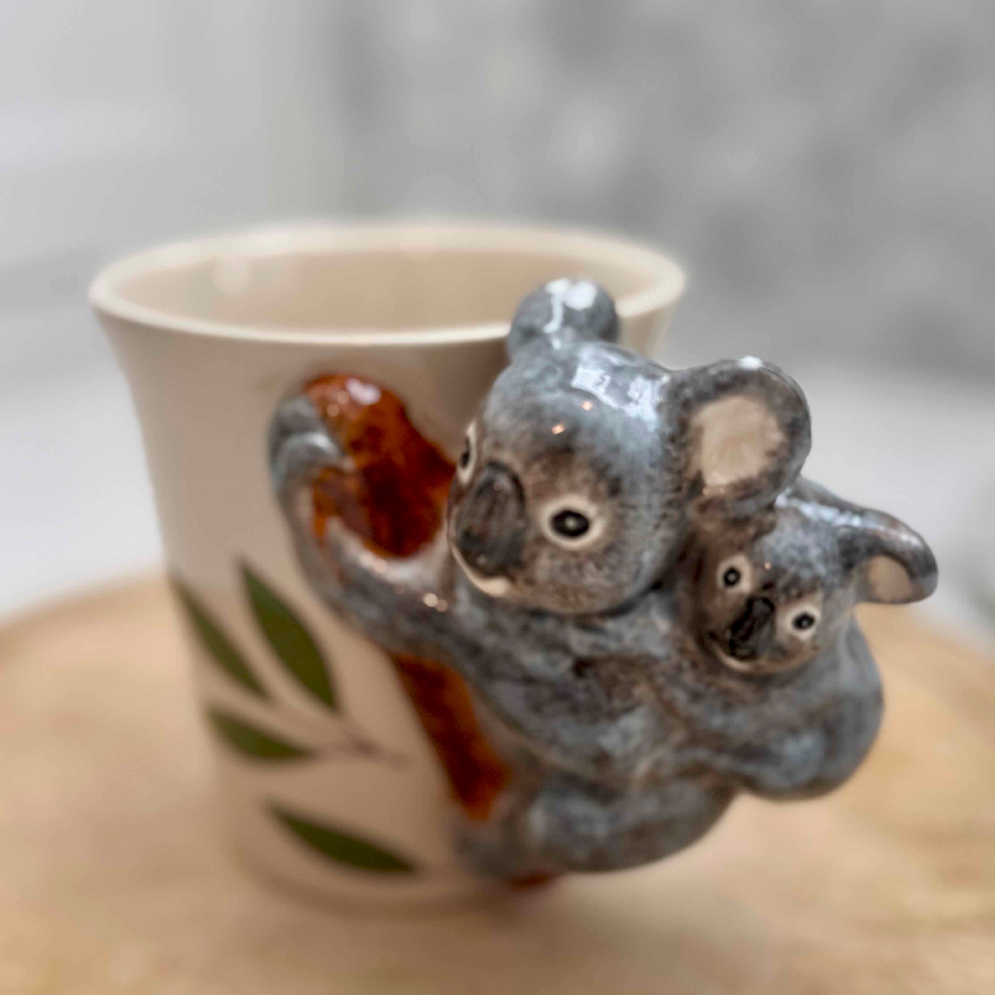 Ceramic cup with koala design on a wooden surface