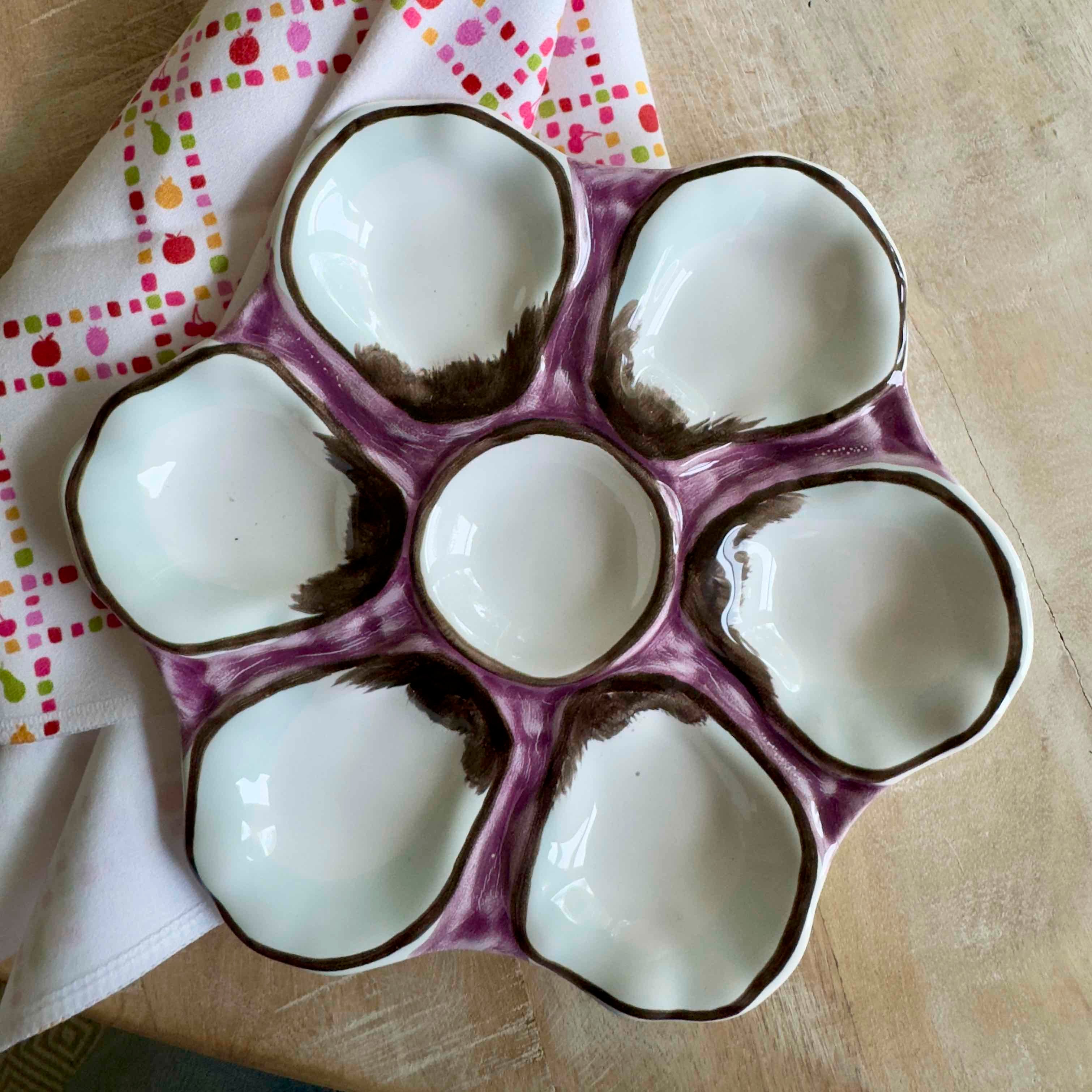 Ceramic egg tray with purple rim on a wooden surface