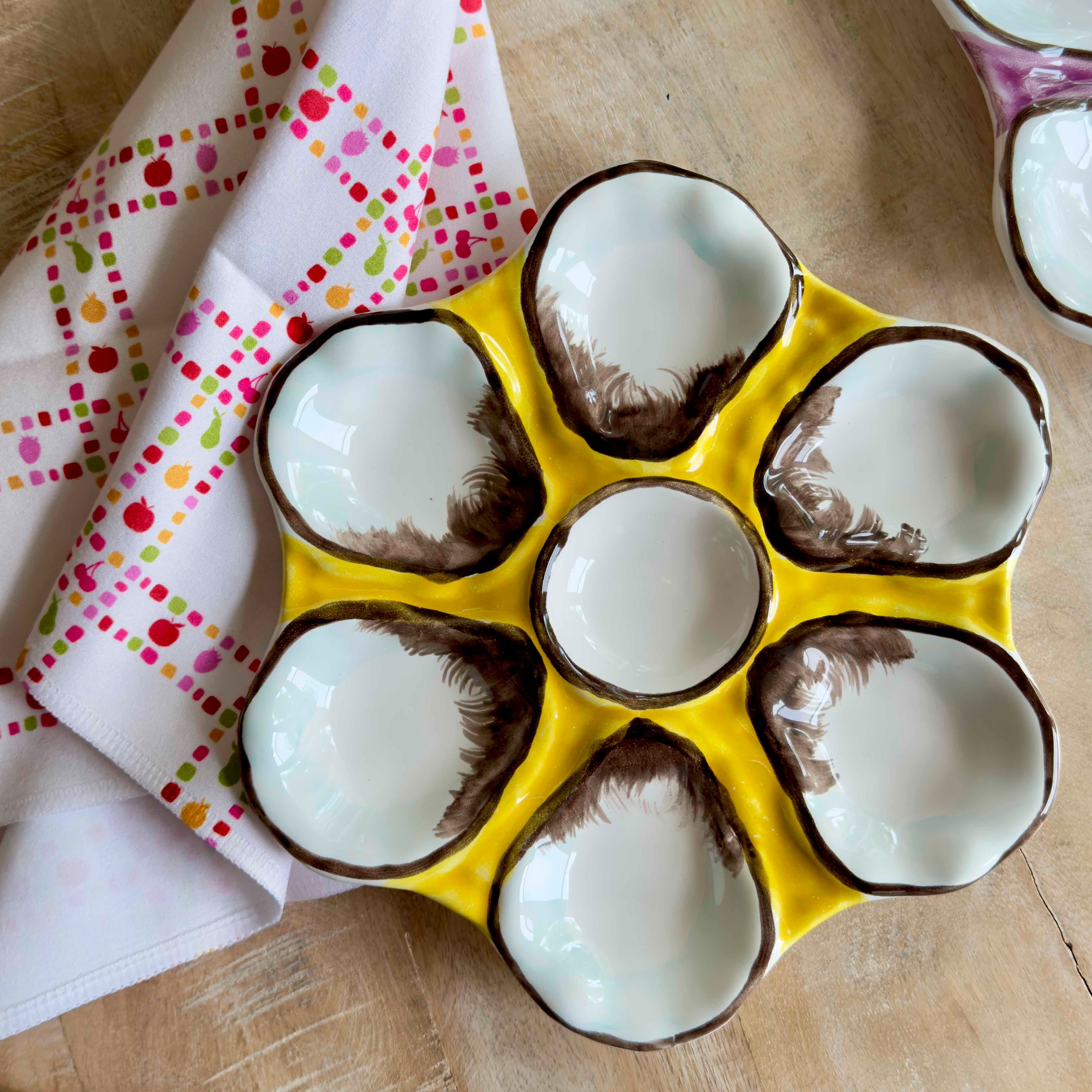 Yellow egg carton with coconut halves on a wooden surface