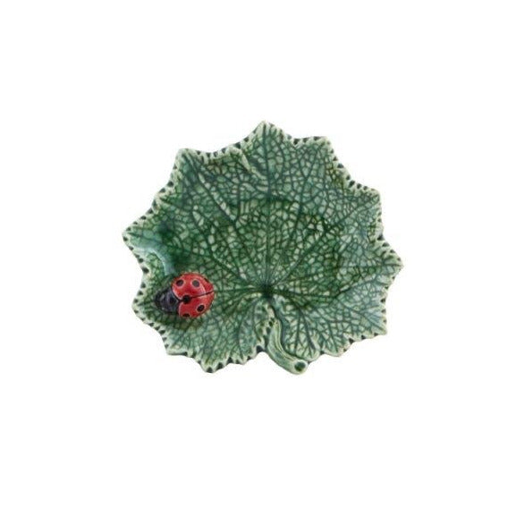 Decorative green leaf-shaped plate with a ladybug on a white background