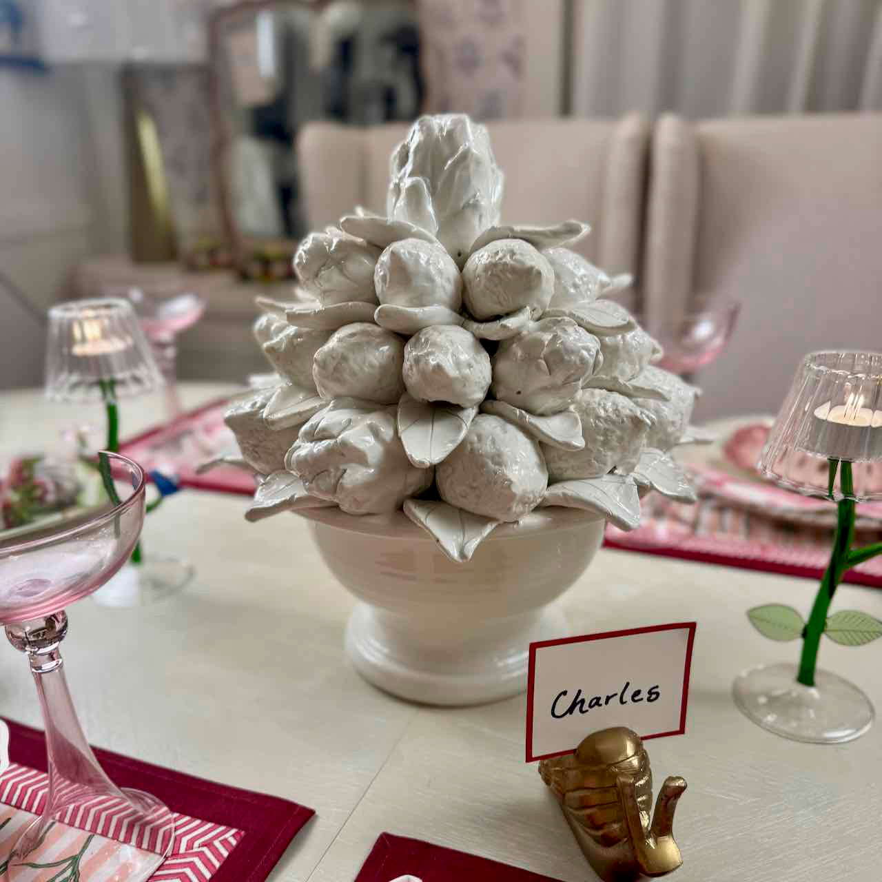Decorative centerpiece with 'Charles' name card on a table setting.