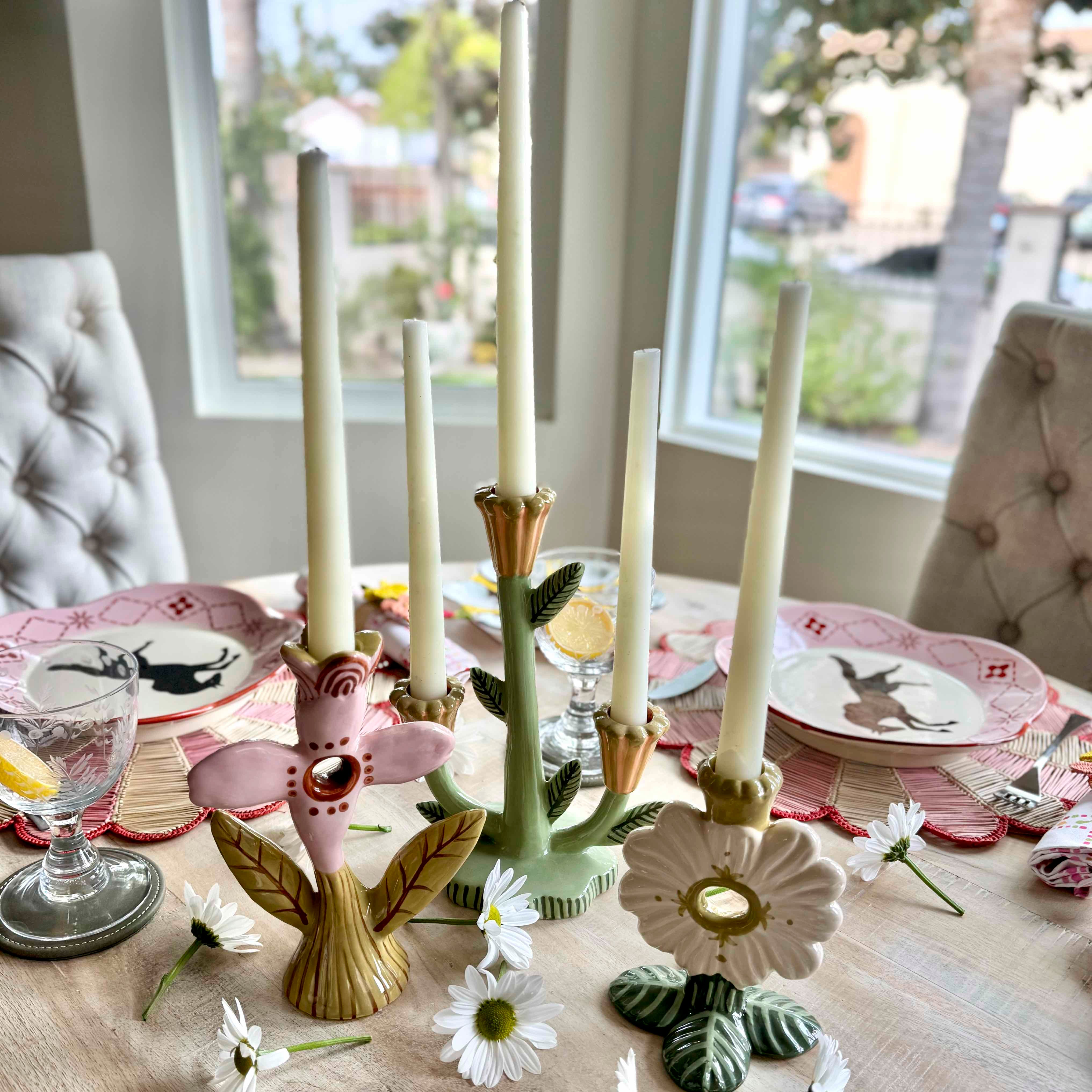 Decorative candle holders on a table with floral designs