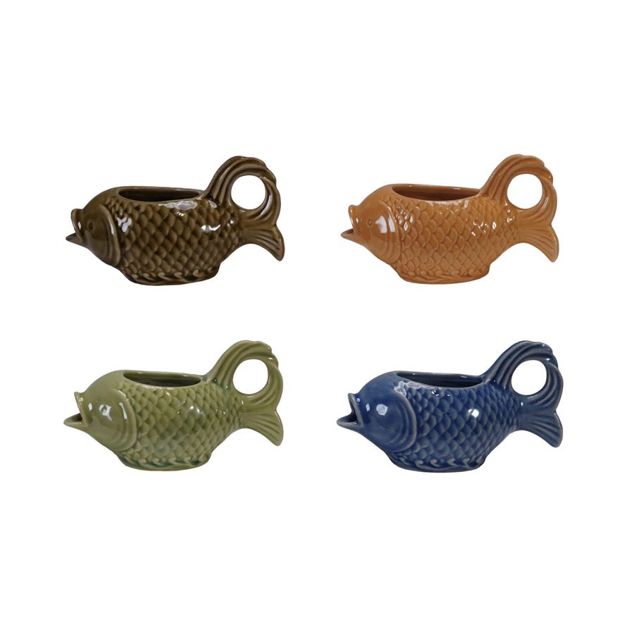 Four fish-shaped ceramic planters in different colors on a white background