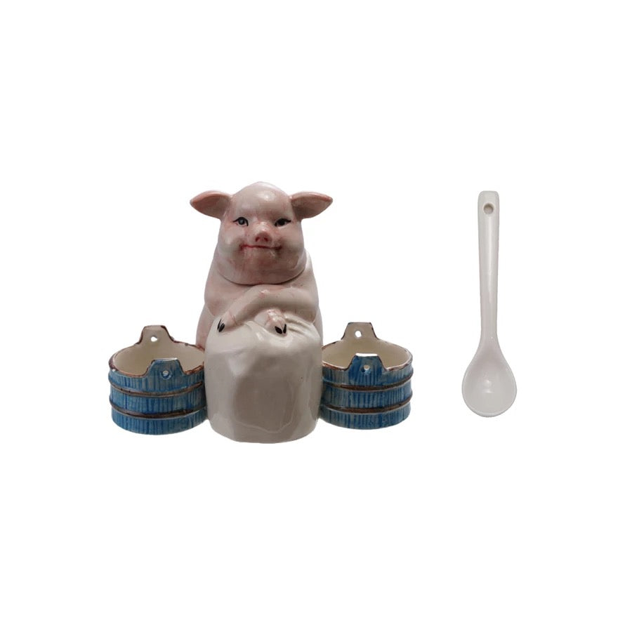 Ceramic piggy bank with three barrels and a spoon on a white background