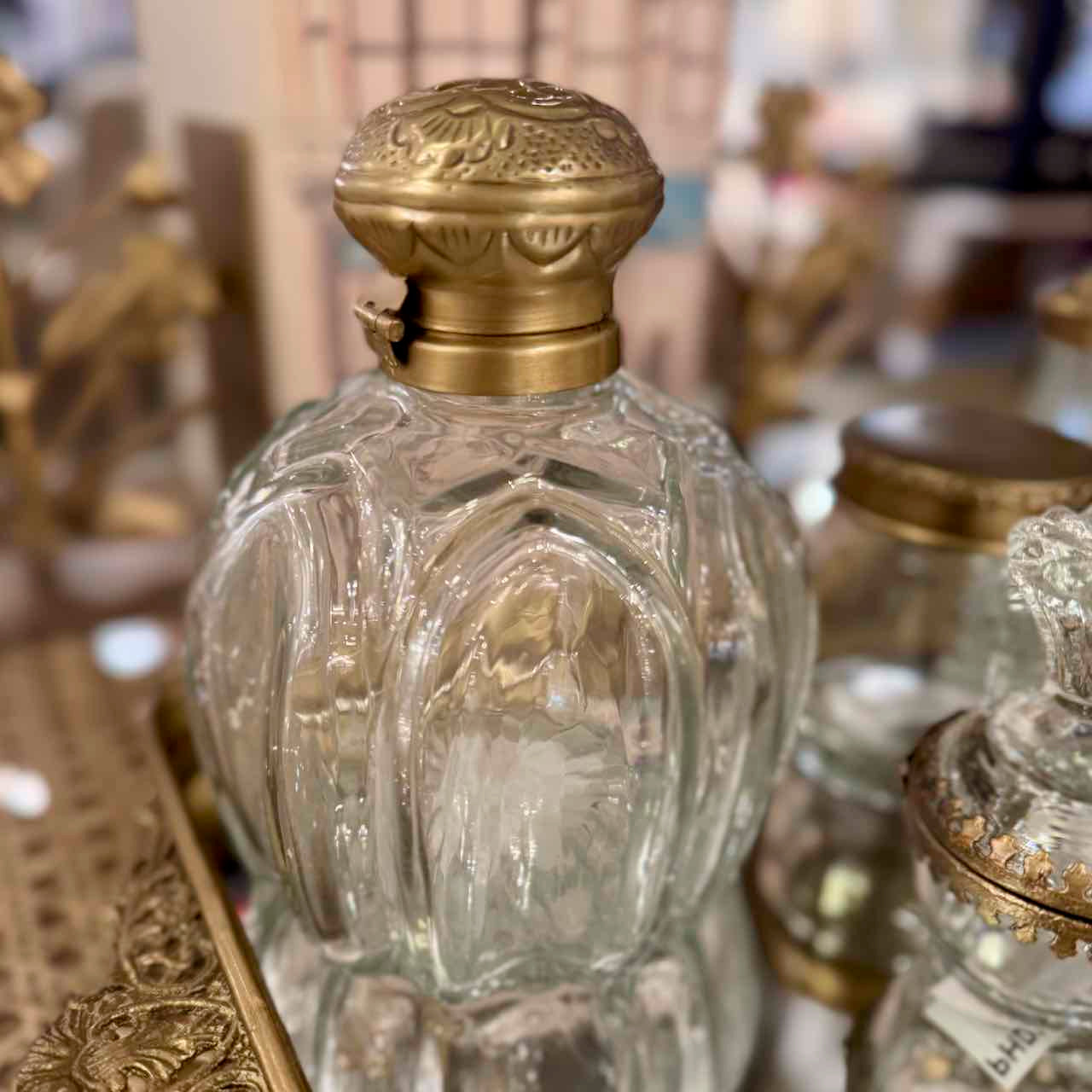 Decorative glass bottle with gold lid on a blurred background