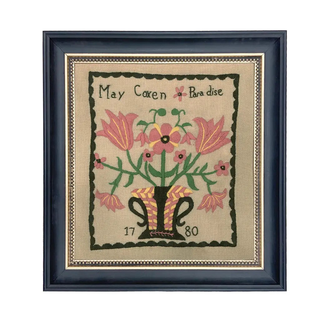 Framed needlepoint with floral design and text on a beige background