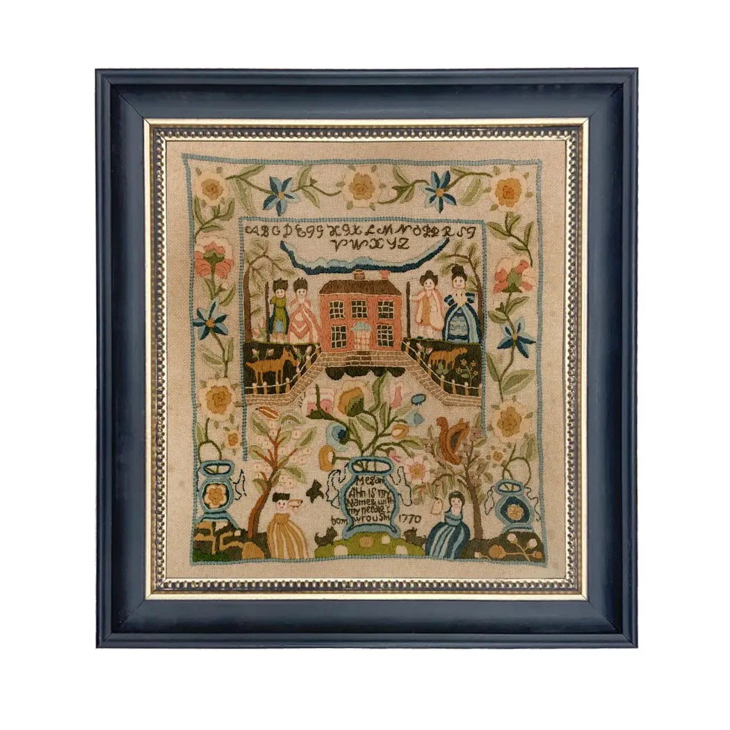 Framed needlepoint print with decorative elements and text on a white background