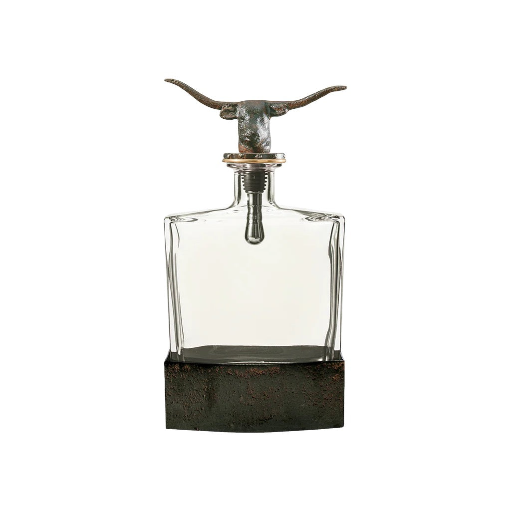 Decorative glass bottle with metal longhorn design on a white background