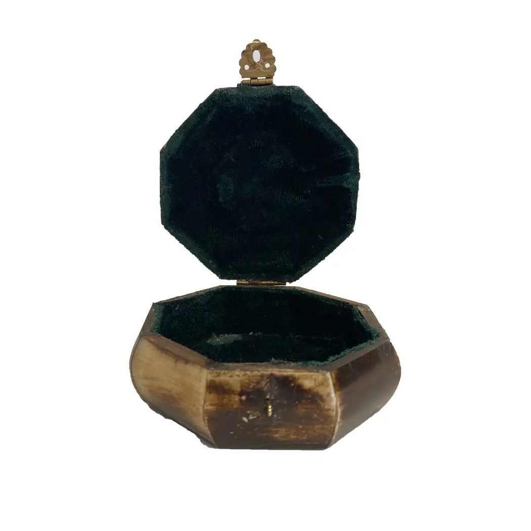 Hexagonal wooden jewelry box with a green velvet interior on a white background