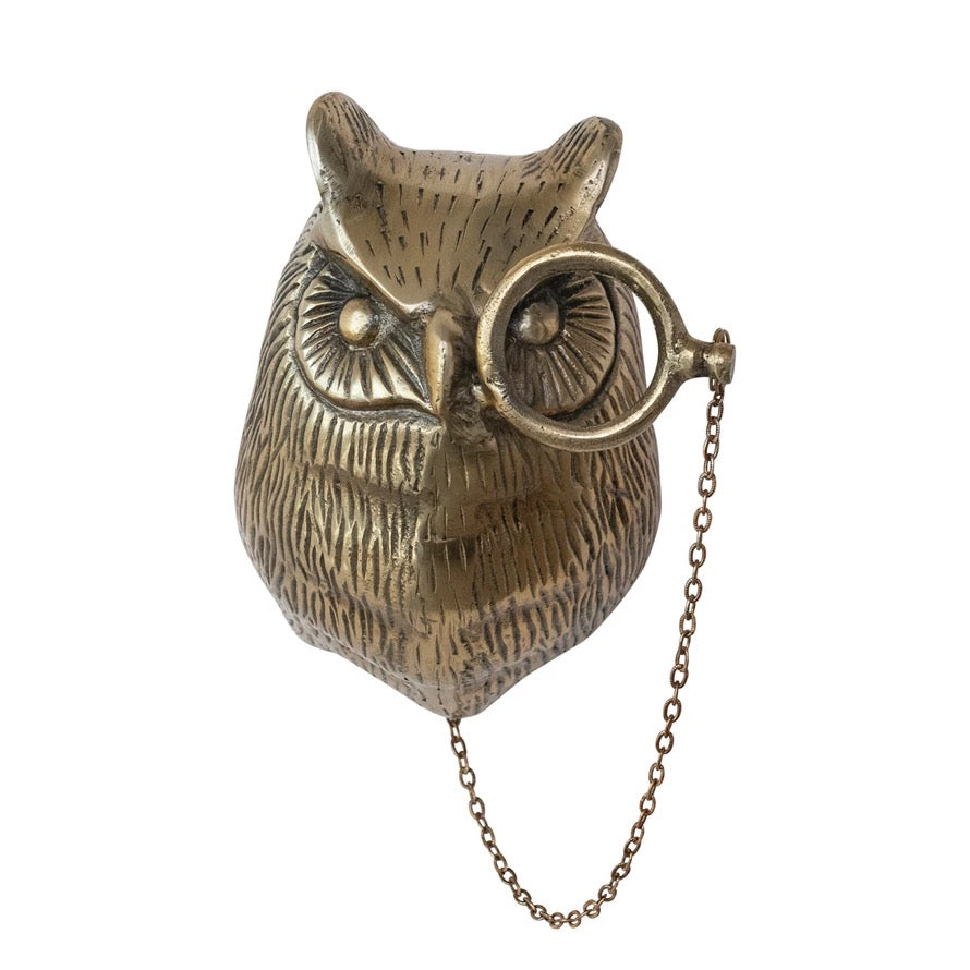 Bronze owl-shaped object with a chain on a white background