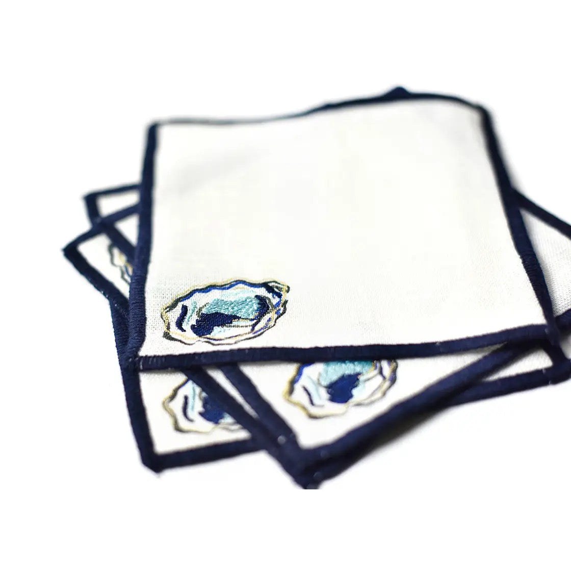 Set of white napkins with blue border and decorative emblem on a white background