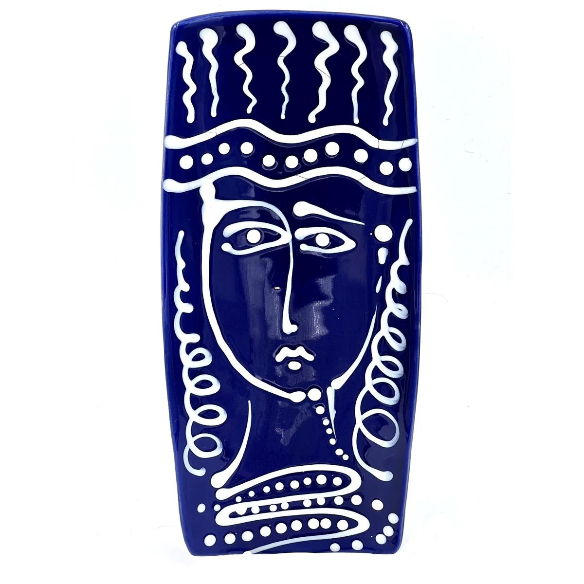 Ceramic wall art with a face design on a blue background