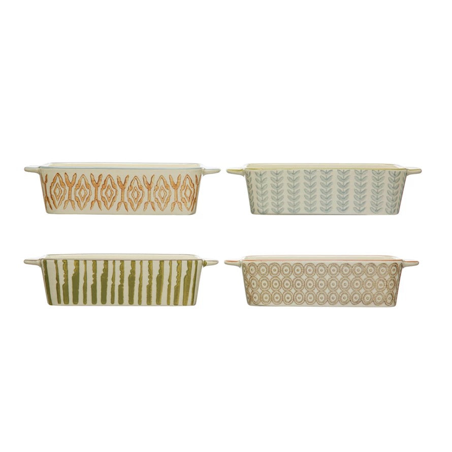 Four ceramic baking dishes with patterned exteriors on a white background