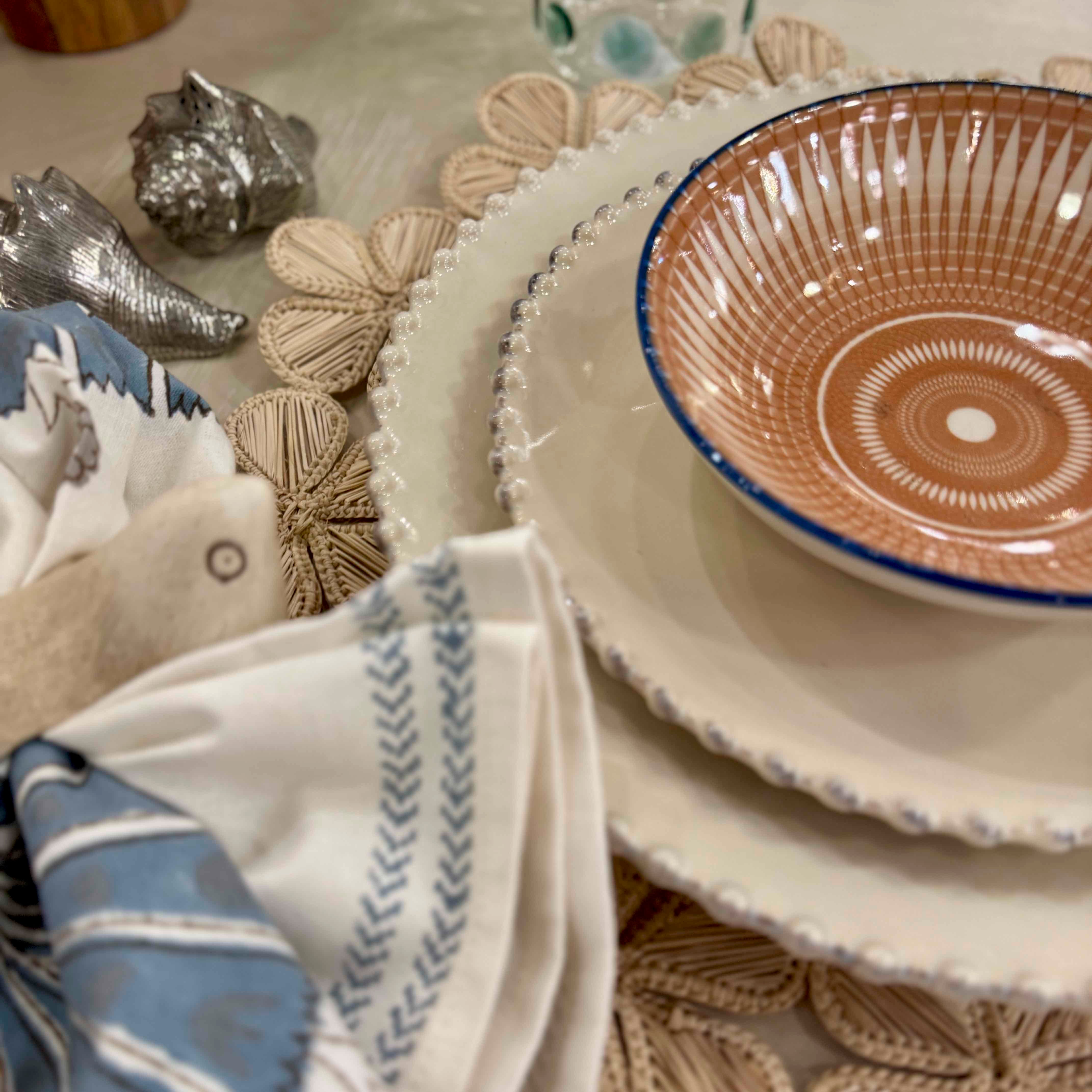 Ceramic plates and bowls with decorative elements on a textured surface