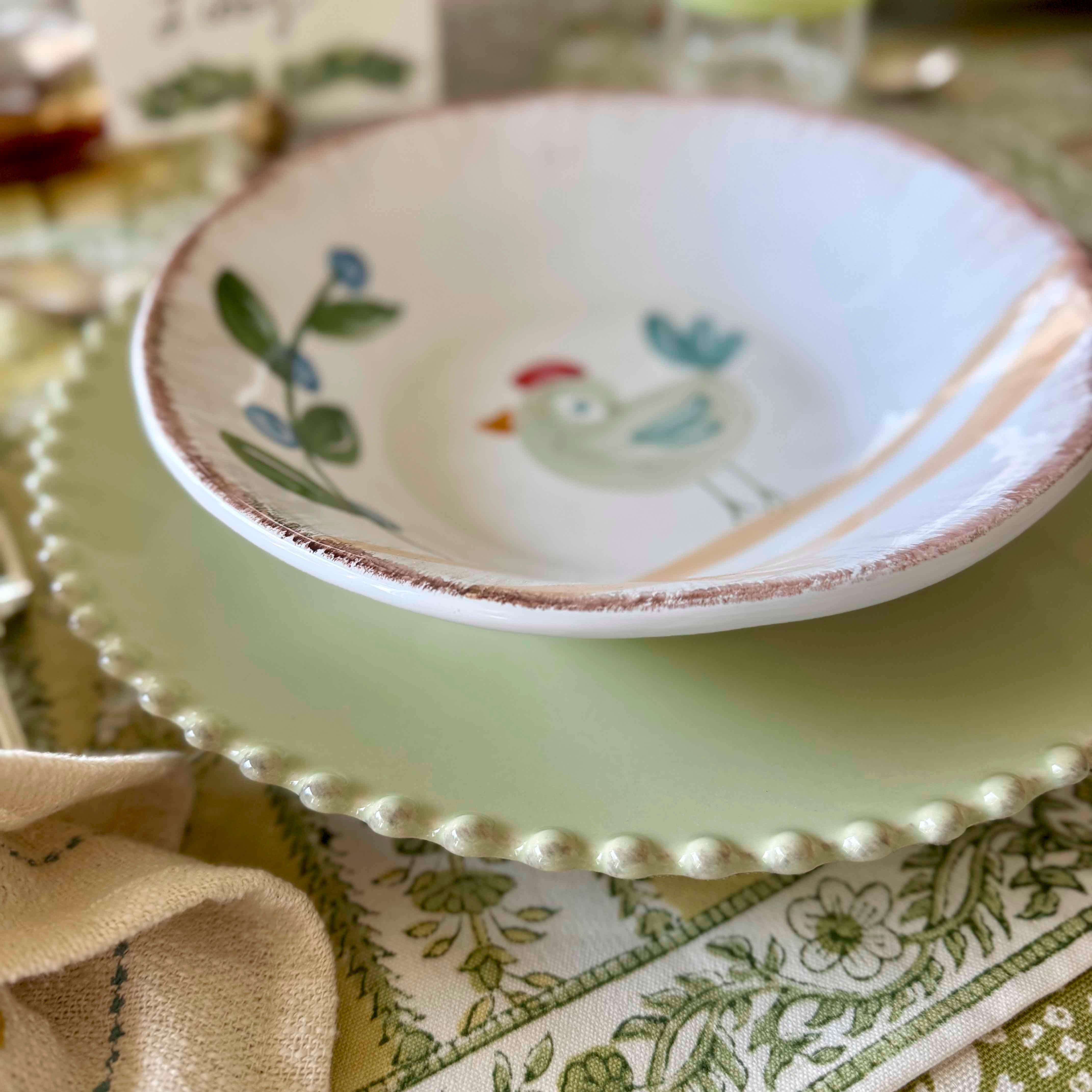 Decorative ceramic plate with a chicken design on a table setting.