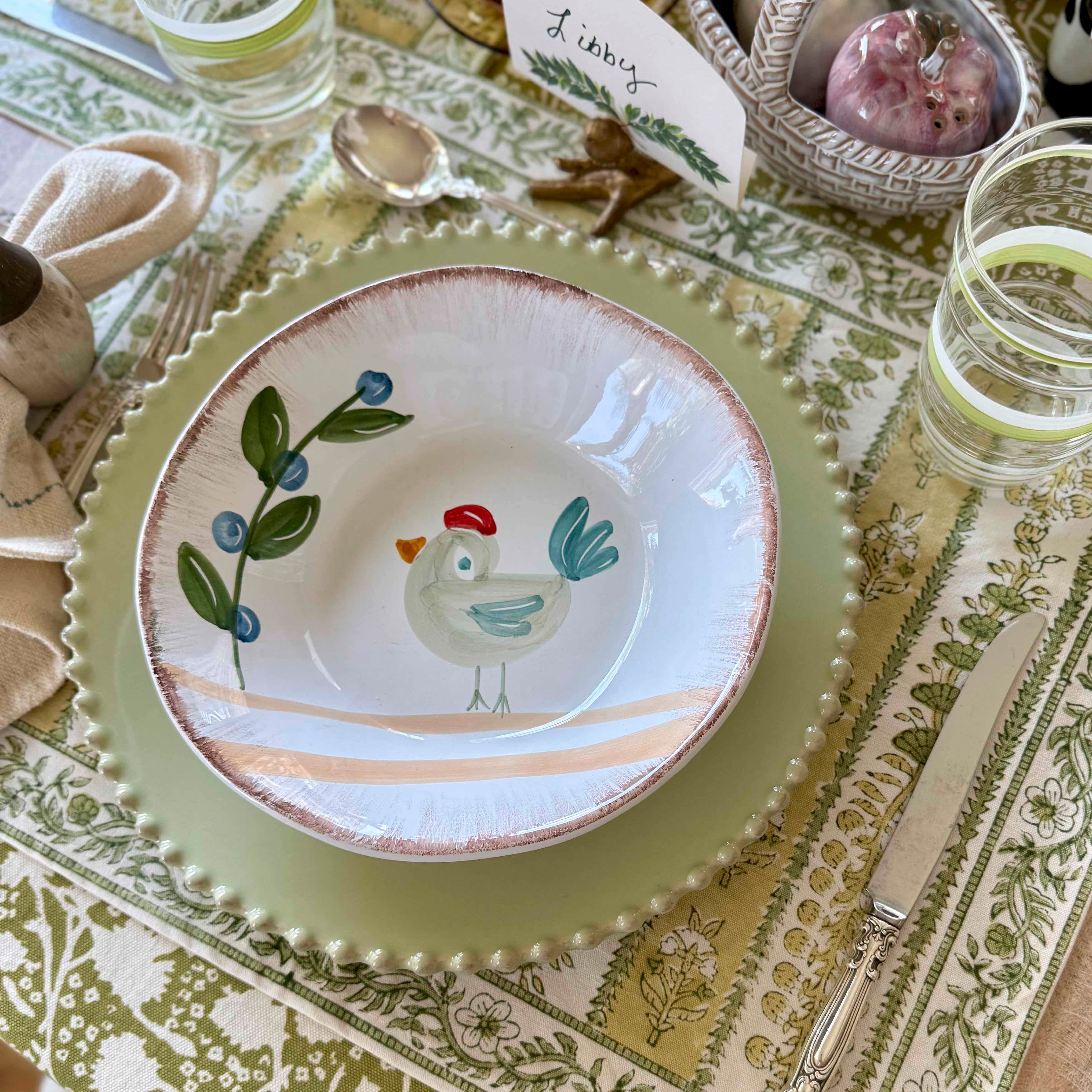 Decorative plate with a chicken design on a patterned tablecloth