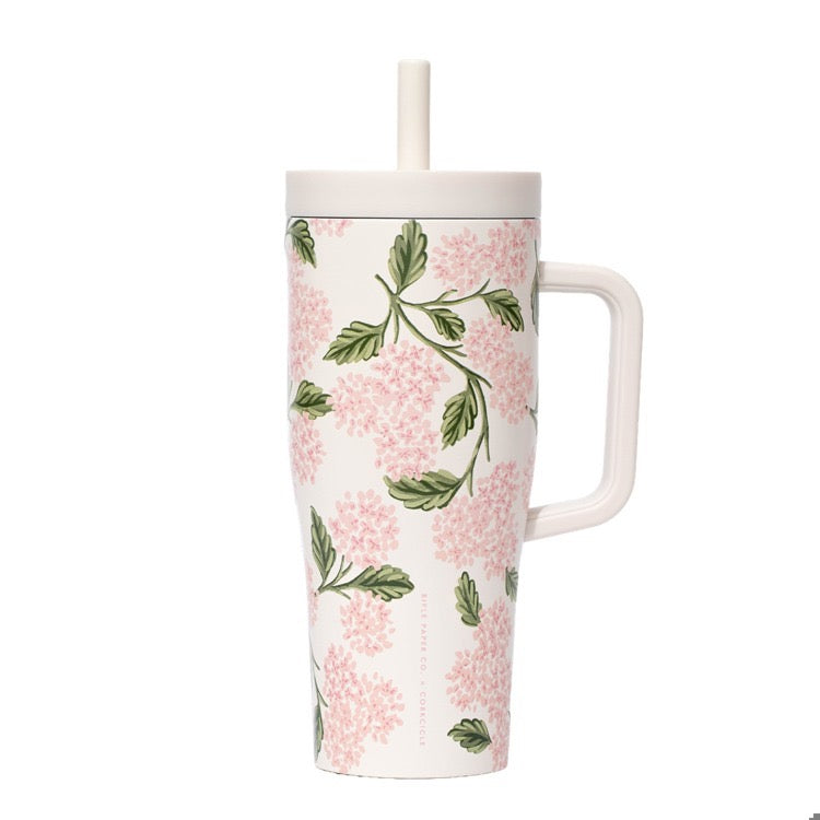 Floral-patterned mug with a handle and straw on a white background