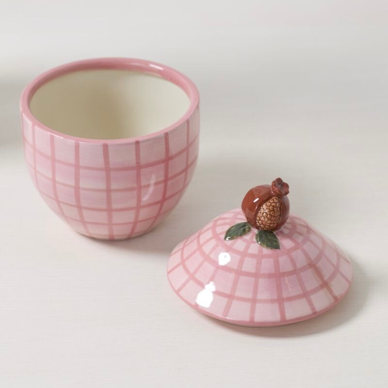 Pink ceramic cup with matching lid on a white background