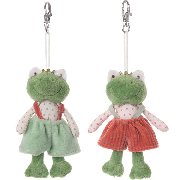 Two green plush frog keychains with red dresses on a white background