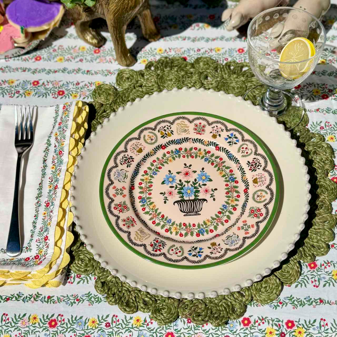 Decorative plate with floral design on a patterned tablecloth