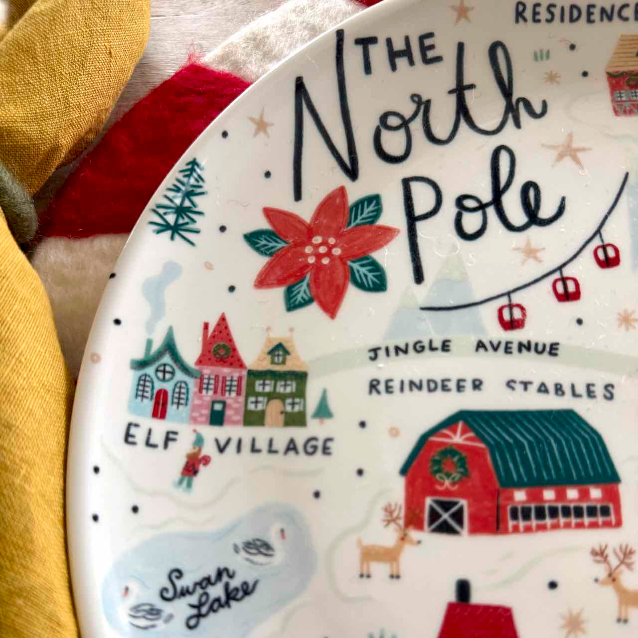 Decorative plate with 'The North Pole' and Christmas-themed illustrations.