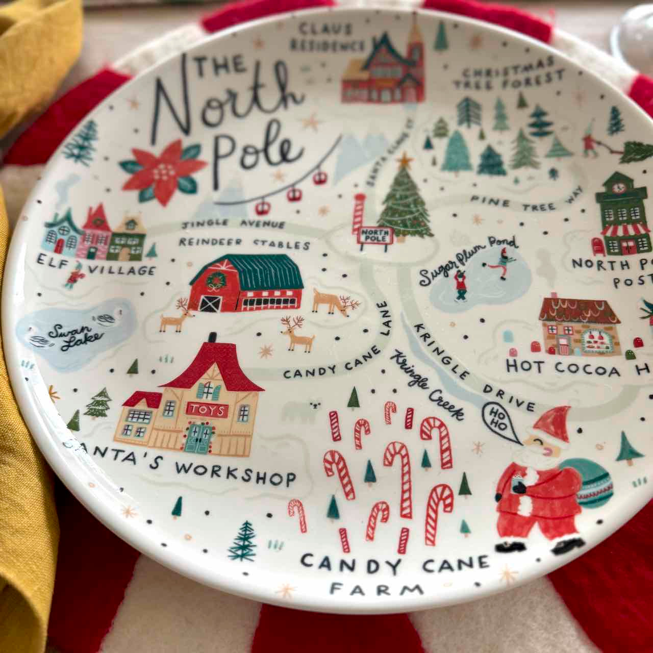 Decorative plate with Christmas-themed design featuring the North Pole and Santa's Workshop.