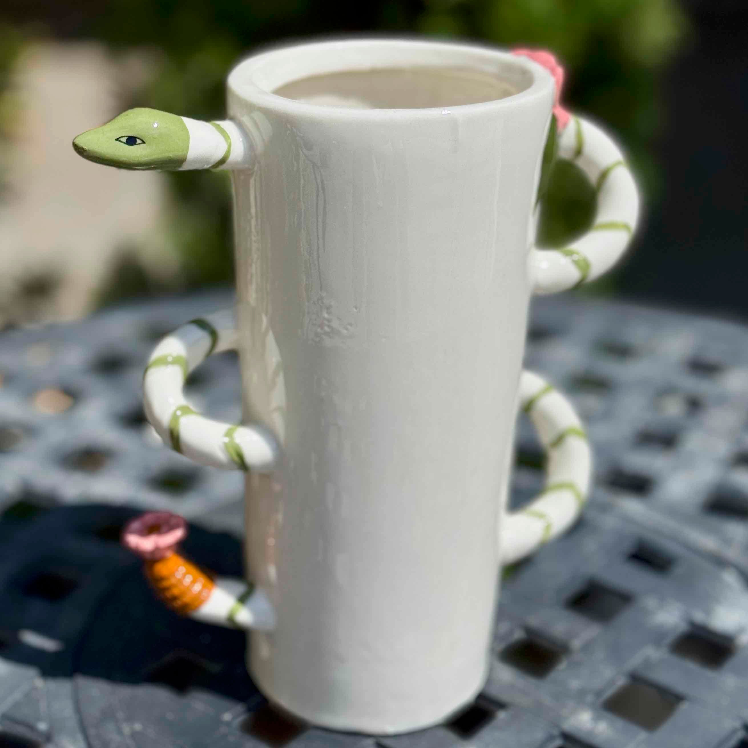 White mug with snake handle on a textured surface