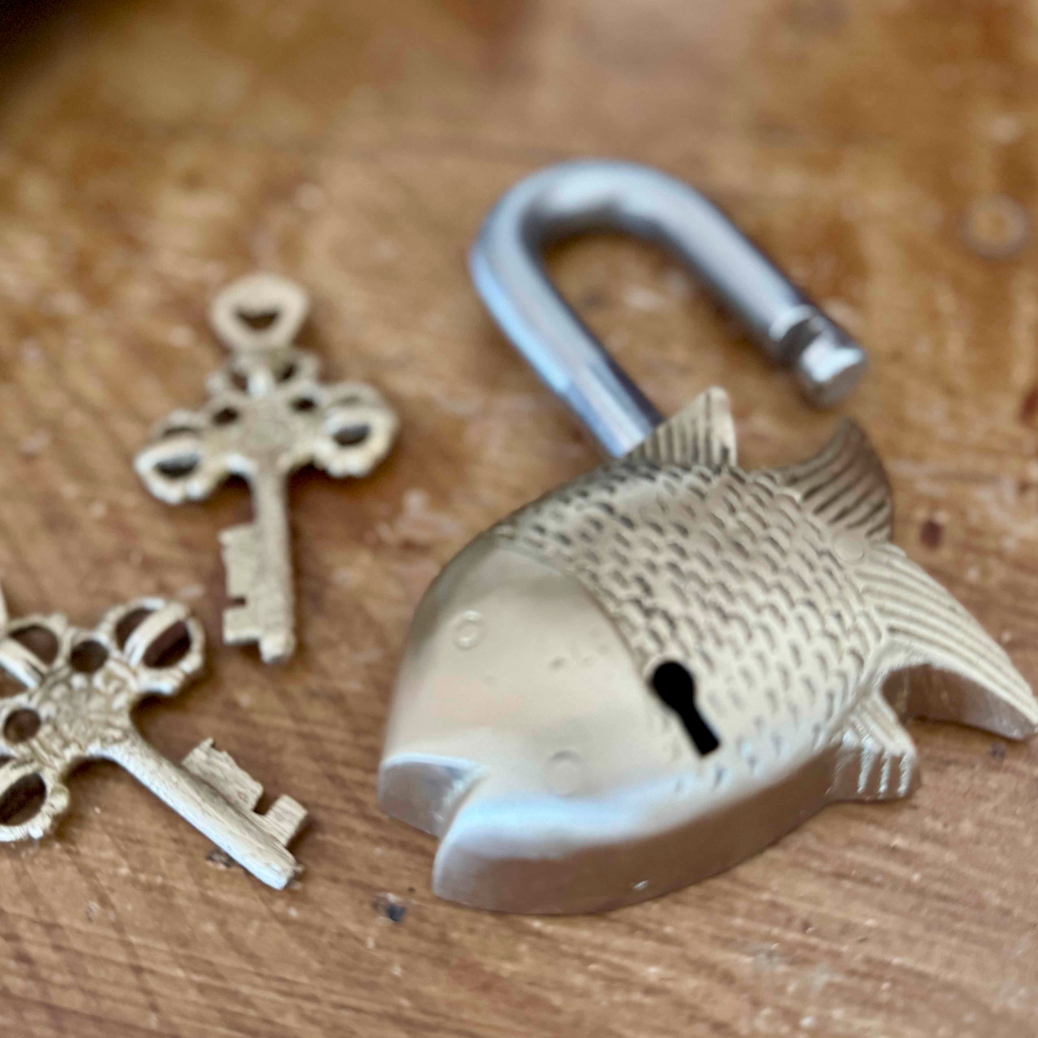 Brass padlock and keys on a wooden surface